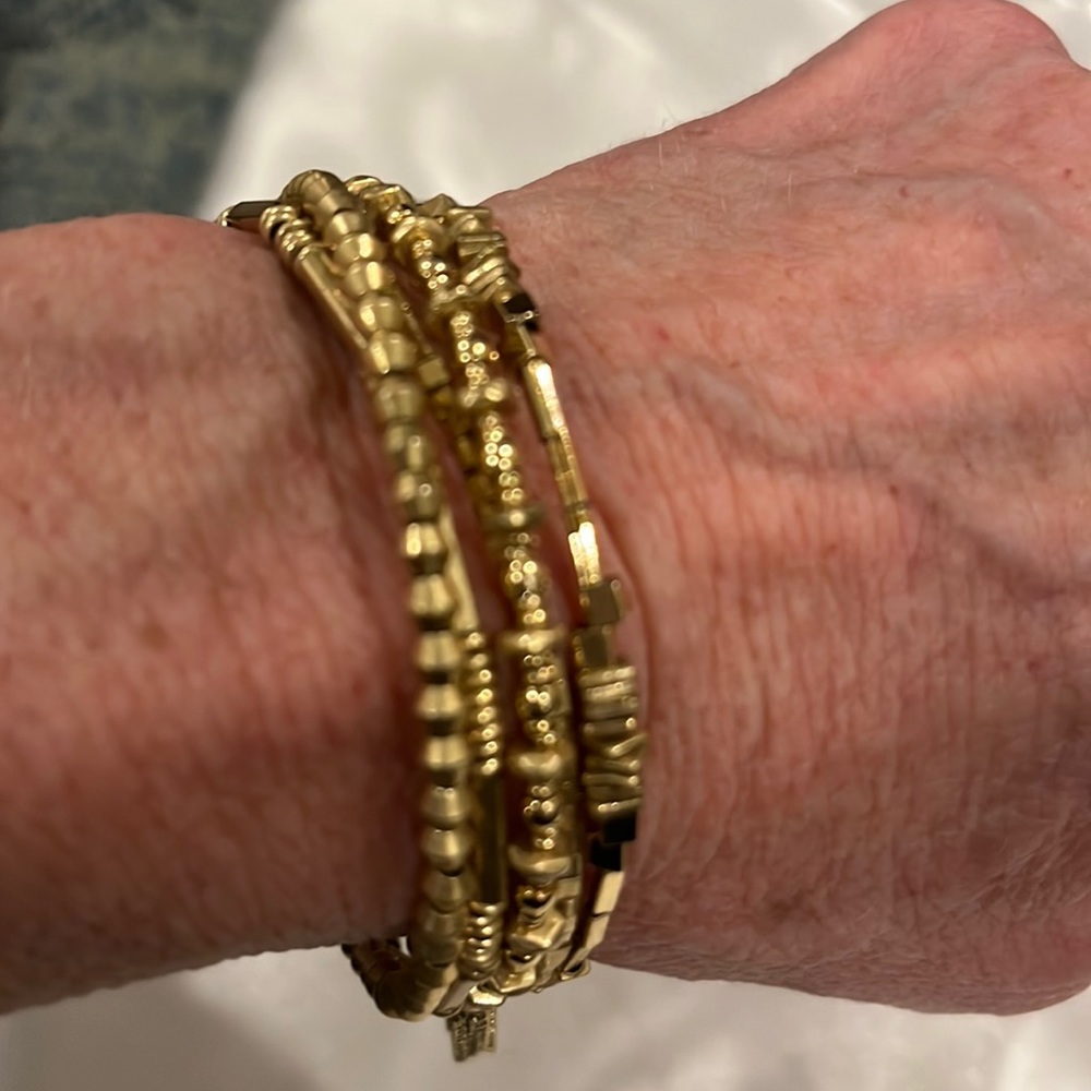 Gold “slinky” wrap bracelet with lots of different textures and gold tassel